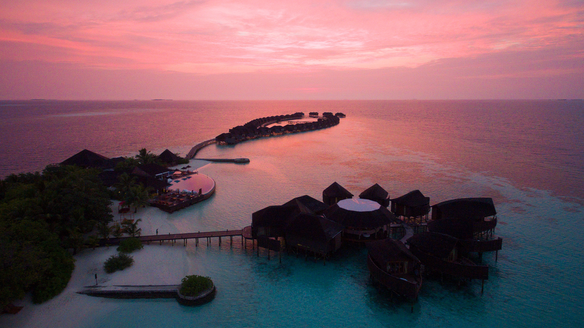 Sunset aerial view of Lily Beach Resort & Spa's over water villas.