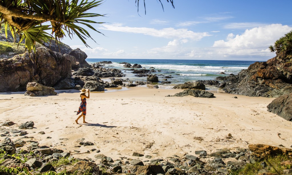 Woman walking on beach in Port Macquarie, NSW, one of Australia's best babymoon destinations