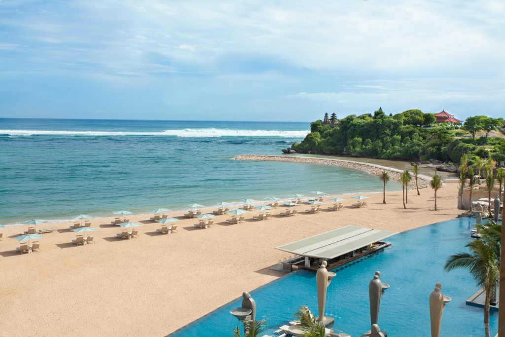 A  view of the private beach from the Mulia Bali Resort, overlooking the turquoise ocean, neighboring cliff and the Ocean Pool