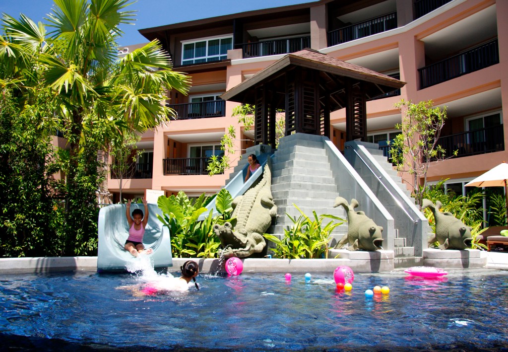 Children enjoying the kid's pool at Pullman Phuket Panwa Beach Resort, where the slide and pool toys make one of The Best Family Resorts in Phuket - Luxury Escapes