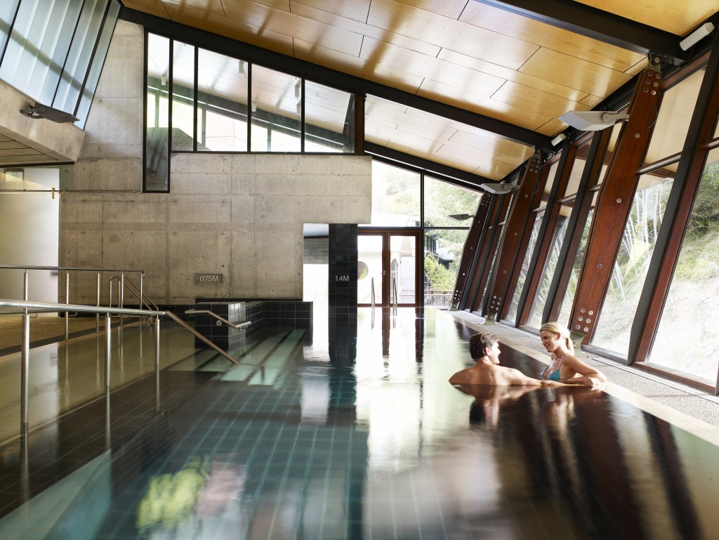 A couple enjoying in a pool at the Hepburn Bathhouse & Spa, Victoria - Luxury Escapes