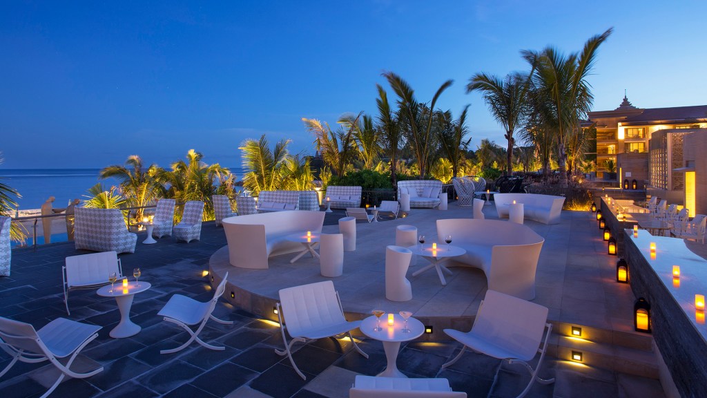 The outdoor setting of Sky Bar at The Mulia at dusk, one of the best rooftop bars in Bali - Luxury Escapes