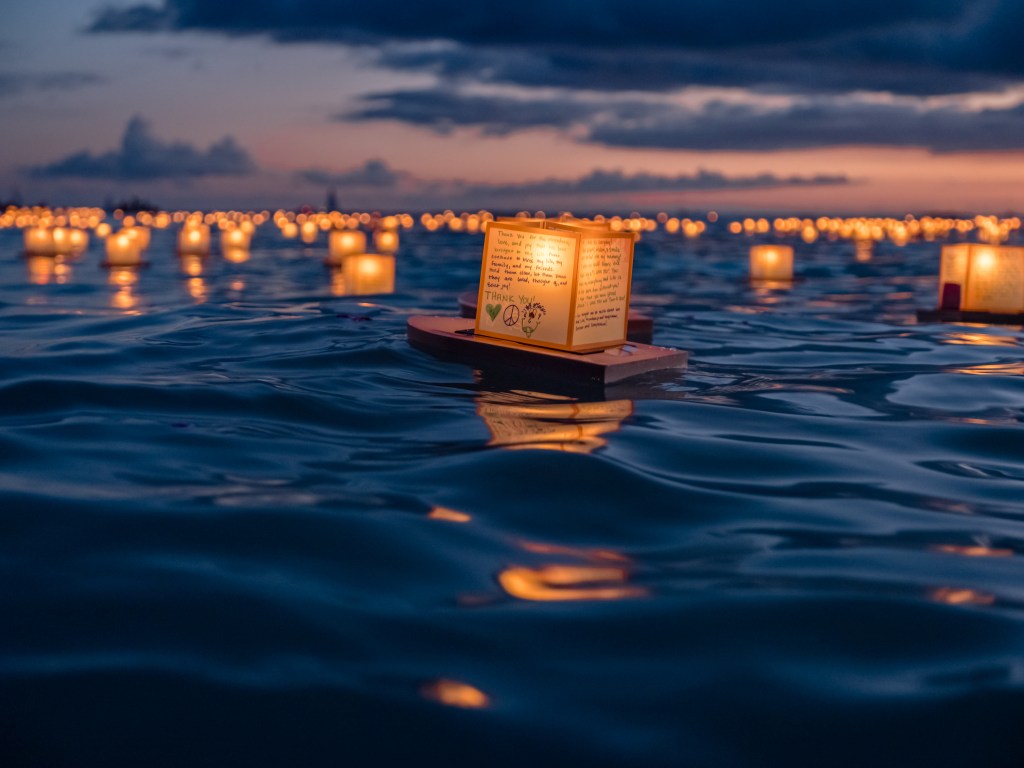 A lantern floats across the water during Shinnyo Lantern Floating Hawai'i, one of the world's best lantern festivals - Luxury Escapes