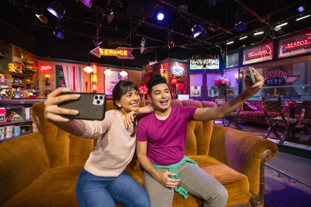 Friends taking a selfie at the iconic Central Perk on a Behind the Scenes Tour of the Friends set at Warner Bros. Studio Tour in Hollywood - Luxury Escapes