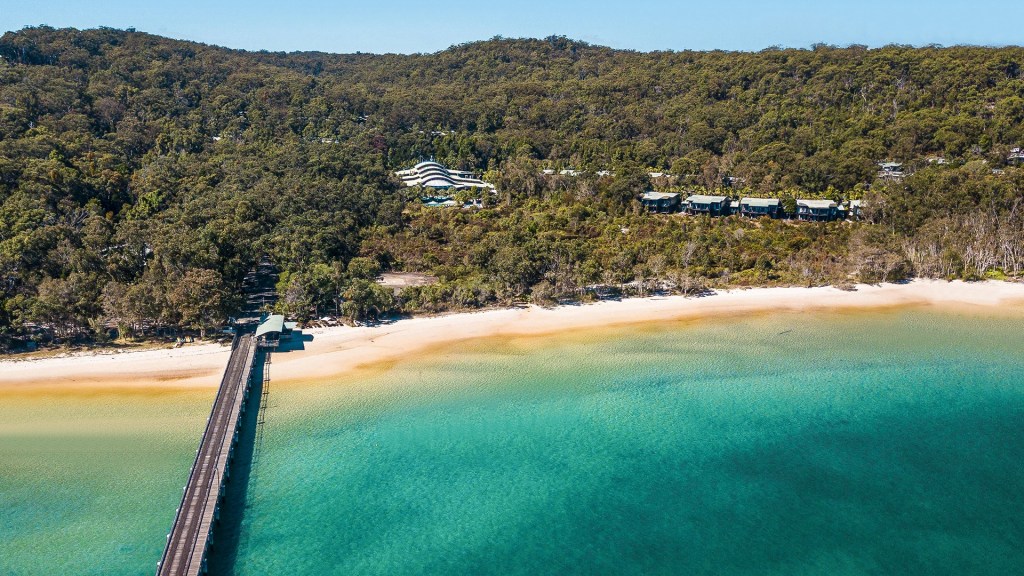 An aerial view of the beach and bay at the Kingfisher Bay Resort in Queensland, one of the best family friendly destinations - Luxury Escapes