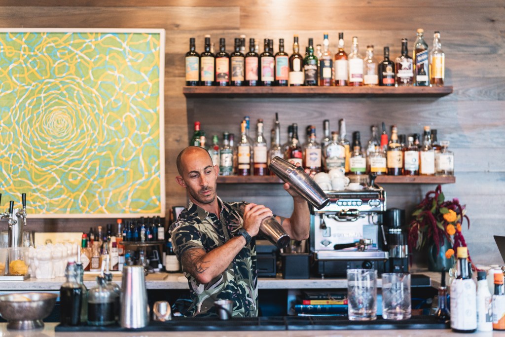 A bartender mixing cocktails at Fete Hawaii in Honolulu, Oahu, one of the best 2023 restaurants in Hawaii - Luxury Escapes 