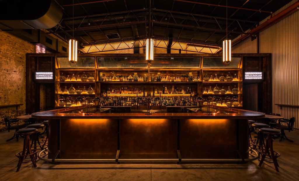 A softly lit bar with plenty of bottle of gin at Archie Rose Distilling Co., one of Sydney's top 10 bars in 2024 - Luxury Escapes