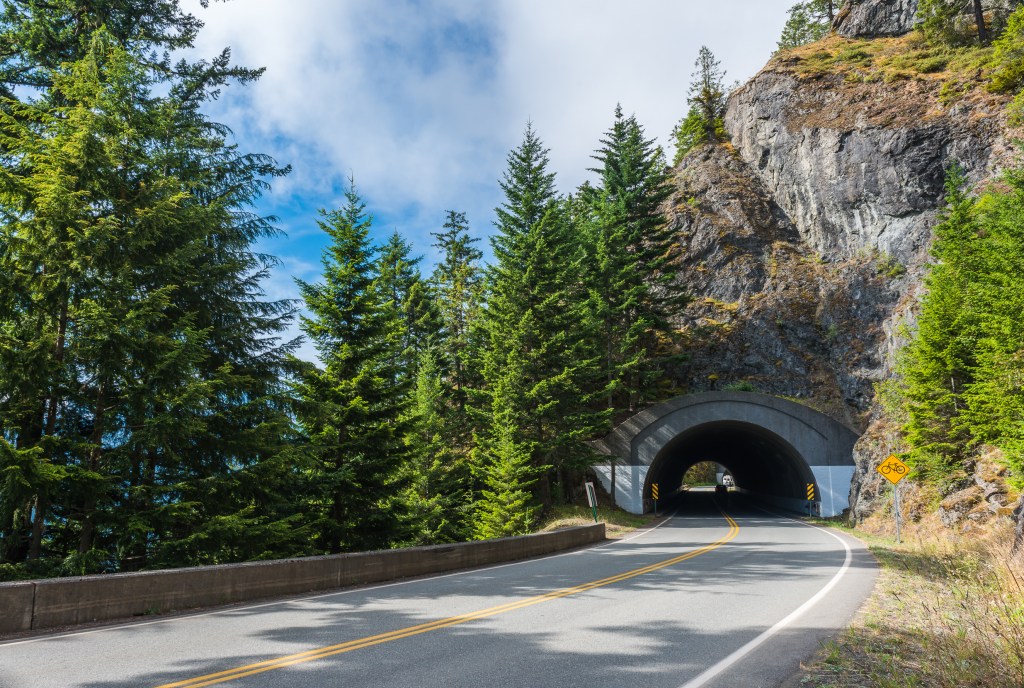 View of the mountains, forest trees and mountain tunnels along the Olympic Peninsula Loop on the 5 most iconic USA road trips - Luxury Escapes