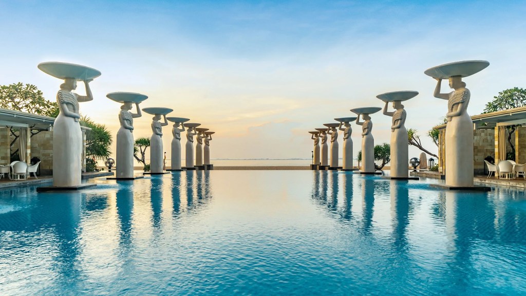 Iconic: the statue-lined Oasis Pool at Mulia Villas in beautiful Bali - Luxury Escapes