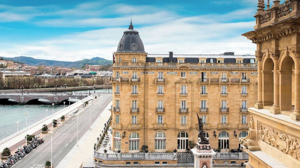 The golden palatial facade of Hotel Maria Cristina, a Luxury Collection Hotel, one of the most extraordinary heritage hotels - Luxury Escapes